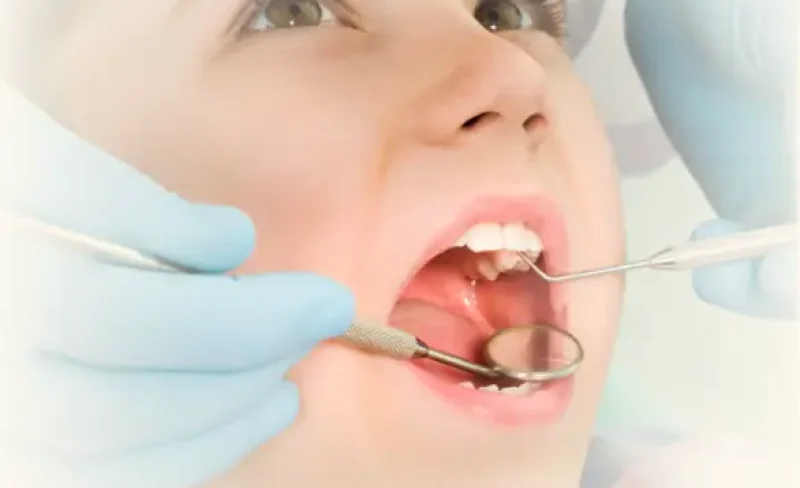 Child receiving a dental checkup from a dentist.