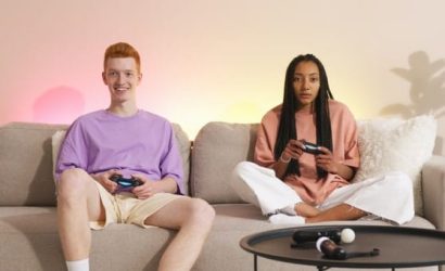 Two people playing video games together on a couch.