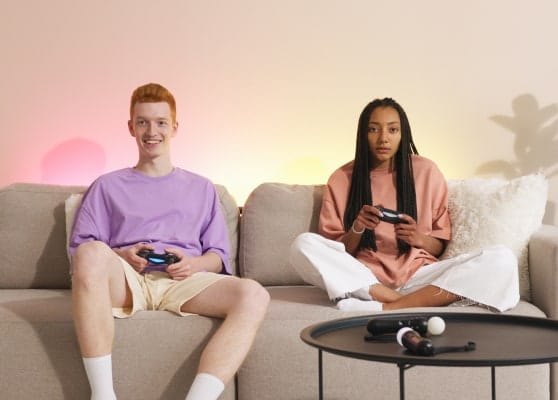 Two people playing video games together on a couch.